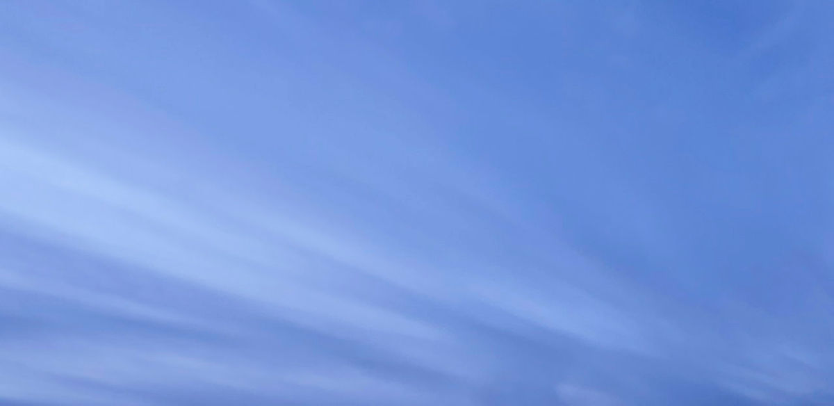 Soft blue sky with wispy, white cirrus clouds.
