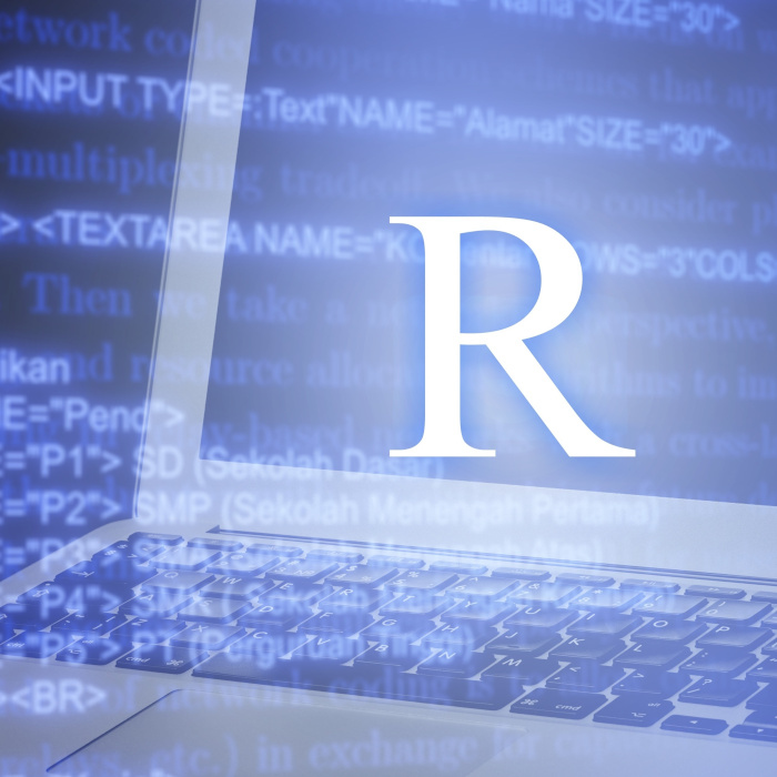 Laptop screen displaying the R programming language logo over a background of source code.